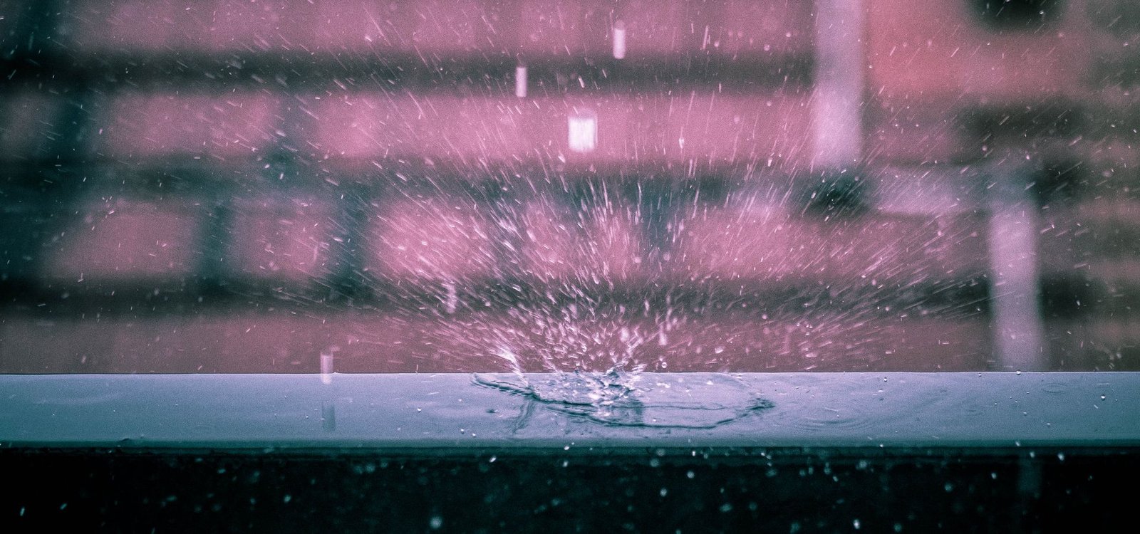 Nettoyage après sinistre et dégât des eaux Goutte d'eau éclatant sur une surface mouillée, évoquant un dégât des eaux